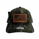 Camouflage Richardson 112 hat with an American flag leather patch on a white background